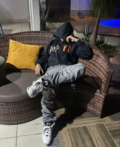 a young man sitting on top of a brown couch