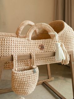 a wicker baby crib with handles and tassels