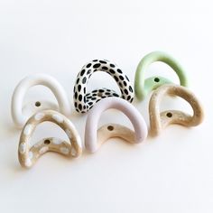 five different colored hair clips on a white surface with polka dot print dots and black spots