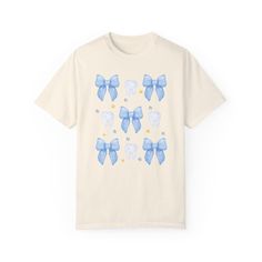 This cute blue bows and teeth Comfort Colors® t shirt is perfect for a Dental Hygienist. It also make a great gift for a dental assistant. - Comfort Colors® Shirts - 100% Ring-Spun Cotton, Medium Fabric - Double-Needle Stitching,  - Unisex Shirt, Relax Fit This is a UNISEX shirt and it's not women's fitted shirt. If you're going for a more fitted look, we suggest to size down. If you like oversized look, please order 1 to 2 sizes up. Please carefully check the size chart in one of the photos before ordering. We suggest you lay your favorite shirt at home flat and measure to compare to the size chart. DESIGN / PRINTING - Direct to garment printing - which is NOT the same as vinyl or decal or iron-on technique - Please note that colors may appear different on different digital screens and ma Cute Blue T-shirt For Gift, Cute Blue Shirt For Gift, Cute Blue Shirt As Gift, Cute Blue Shirt As A Gift, Blue Short Sleeve T-shirt For Gift, Dental Shirt, Dental Nurse, Dental Assistant Gifts, Dental Shirts