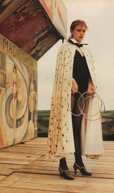 a woman standing on top of a wooden floor holding two hoops in her hands