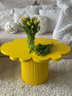 a yellow coffee table with flowers in it