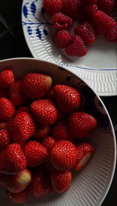 two plates with strawberries on them and one plate full of strawberries in it