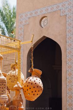 several decorative objects hanging from the ceiling in front of a building with arches and windows