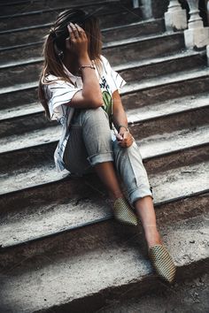 a woman sitting on the steps talking on her cell phone