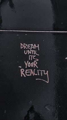 graffiti written on the side of a black vandalized with words dream until it's your reality