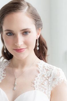 a woman in a white dress wearing earrings