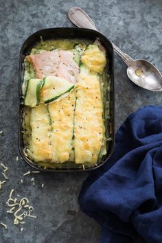 a casserole dish with zucchini, ham and cucumber in it