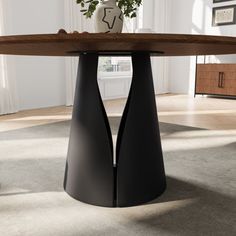 a wooden table with black metal legs and a vase on the top, in a white room