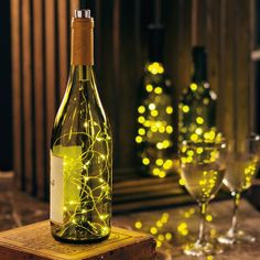 a bottle of wine sitting on top of a wooden box next to two glasses filled with wine