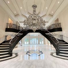 an elegant staircase with chandelier and marble floors