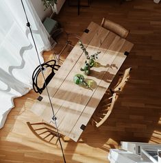 an overhead view of a dining room table with chairs and potted plants on it