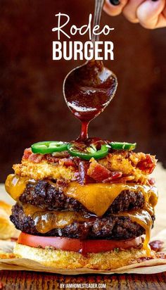 a person is pouring ketchup on a hamburger