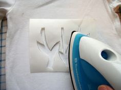 a person is ironing some white paper with a blue and white iron on it