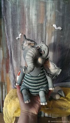 an elephant figurine sitting on top of a wooden table next to a wall