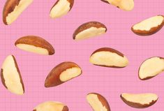 some nuts on a pink background with one half peeled and the other half unpeeled