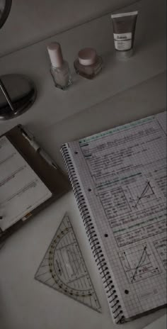 an open notebook sitting on top of a white desk next to a pen and paper