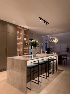 a modern kitchen with marble counter tops and bar stools