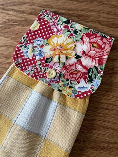 a close up of a piece of cloth on a wooden table with flowers and polka dots