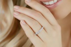 a close up of a woman's hand with a diamond ring on her finger