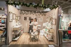 a room filled with furniture and pictures on the wall next to a christmas wreath hanging from the ceiling