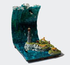 a lego model of a lighthouse in the middle of a wave with people on it