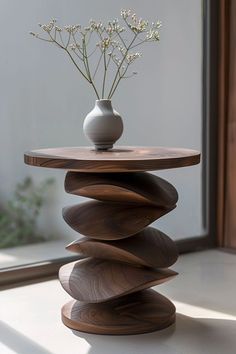 a vase with flowers sitting on top of a wooden table in front of a window