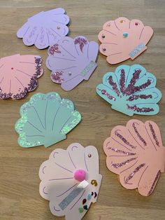 paper flowers with sequins on them sitting on top of a wooden table next to scissors