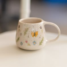 a white coffee cup sitting on top of a table