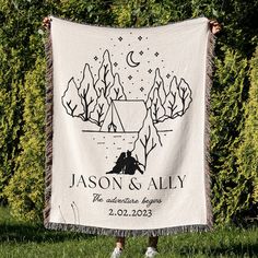 a person holding up a white and black tapestry with the words, mason & ally on it