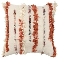 an orange and white pillow with fringes on it