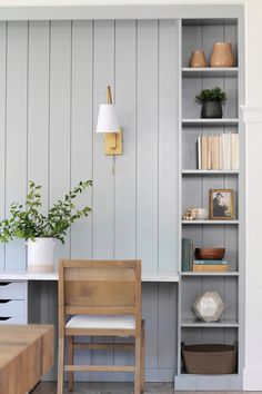 a chair sitting in front of a bookshelf filled with lots of books and plants