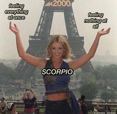 a woman standing in front of the eiffel tower with her arms up and saying scorpio