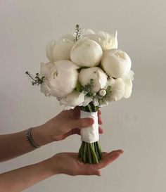 a person holding a bouquet of white flowers