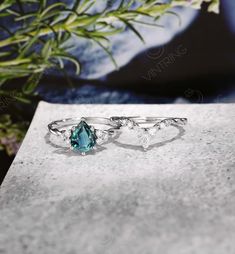 two rings sitting on top of a table next to a flower pot with flowers in the background