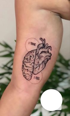 a black and white photo of a human heart tattoo on the left calf leg, with words think i feel