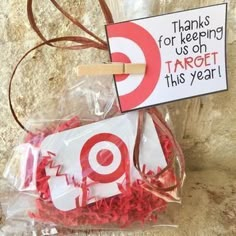 a bag filled with red shredded paper next to a sign that says thanks for keeping us on target this year