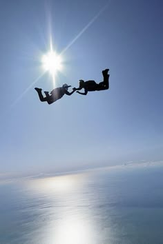 two people are diving into the water