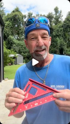 a man holding up a piece of red construction paper