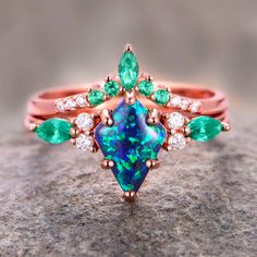 Indulge in the timeless elegance of our Skye Blue Fire Opal & Emerald Ring Set, crafted exclusively for women seeking sophistication and allure. Delicately encased in luxurious 14K rose gold vermeil, this engagement ring radiates with ethereal beauty.►The centerpiece features a captivating Skye Blue Fire Opal, renowned for its mesmerizing play of colors reminiscent of the sky at dawn. Enhanced by the vibrant allure of emeralds, each gemstone exudes a natural brilliance, symbolizing growth, renew Elegant Rose Gold Emerald Promise Ring, Formal Rose Gold Emerald Ring With Accent Stones, Elegant Rose Gold Emerald Ring In 14k, Elegant 14k Rose Gold Emerald Ring, Elegant Emerald Rose Gold Rings, Formal Multi-stone Rose Gold Jewelry, Elegant Rose Gold Emerald Ring For May Birthstone, Elegant Rose Gold Ring With Emerald, Formal Rose Gold Multi-stone Jewelry