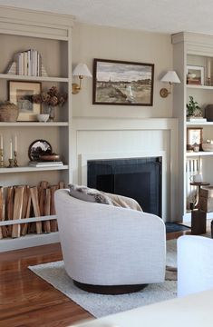 a living room filled with furniture and a fire place next to a book shelf full of books