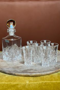 an assortment of glasses and a bottle on a tray