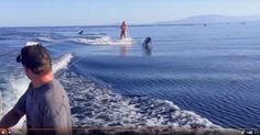 a man riding on top of a boat in the ocean