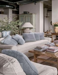 a living room filled with furniture and lots of pillows on top of it's couches