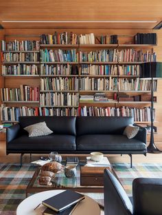 a living room filled with furniture and bookshelves full of bookcases next to a coffee table