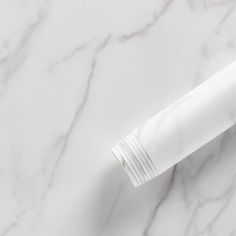 a white pen sitting on top of a marble surface