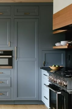 a kitchen with gray cabinets and wood floors