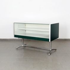 a green and white cabinet sitting on top of a tile floor