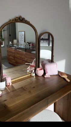 a wooden table topped with a mirror next to a dresser