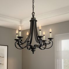 a chandelier hanging from the ceiling in a room with gray walls and white trim